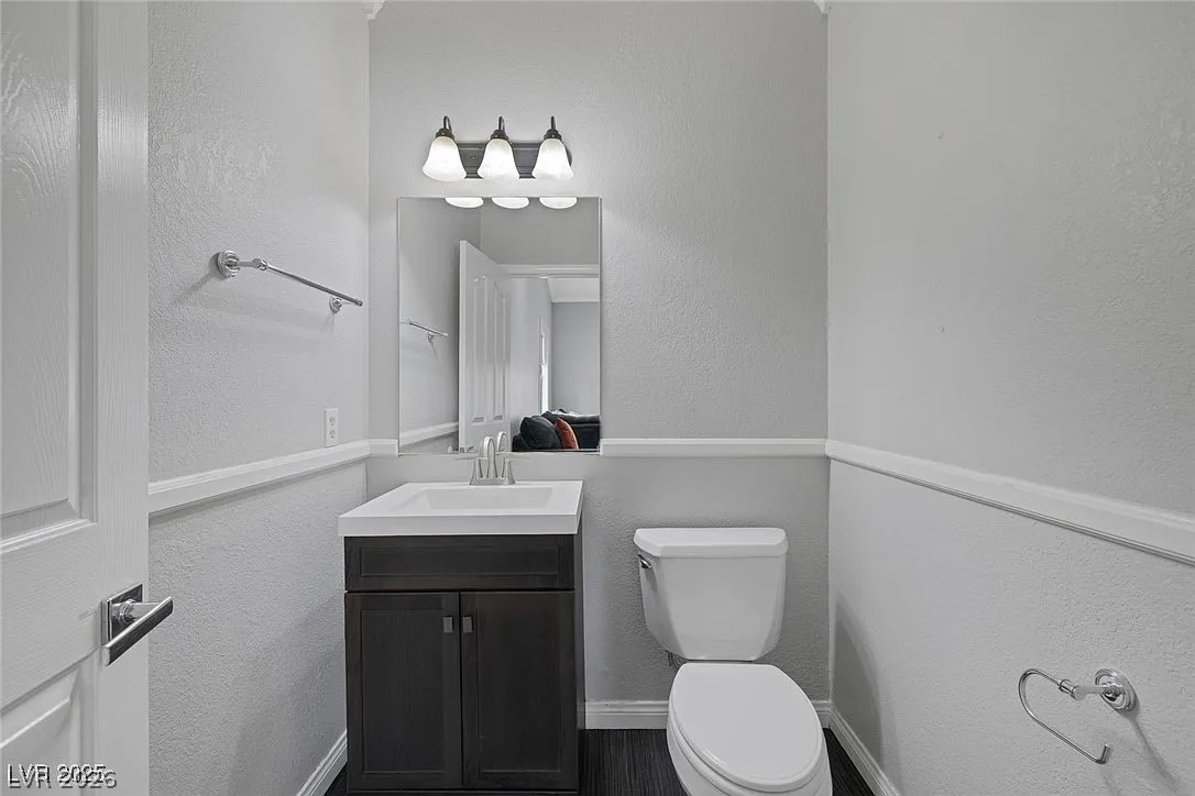 9 Quail Run Road Henderson, NV 89014 - Photo 37 of 57 A well-appointed half bath features dark wood cabinetry, a contemporary vanity, and polished chrome fixtures.
