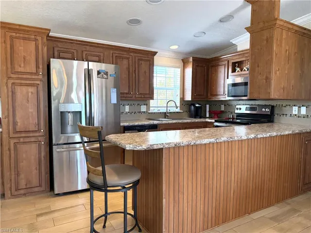 a kitchen with kitchen island granite countertop a sink cabinets and refrigerator