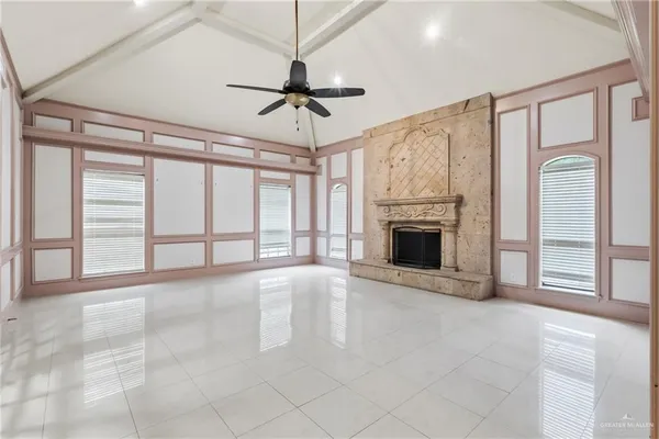 a view of an empty room with a fireplace and a window
