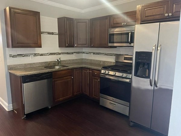 50 Faunce Road, Unit 1 Boston, MA 02126 - Photo 1 of 1 a kitchen with stainless steel appliances a stove a sink and a microwave
