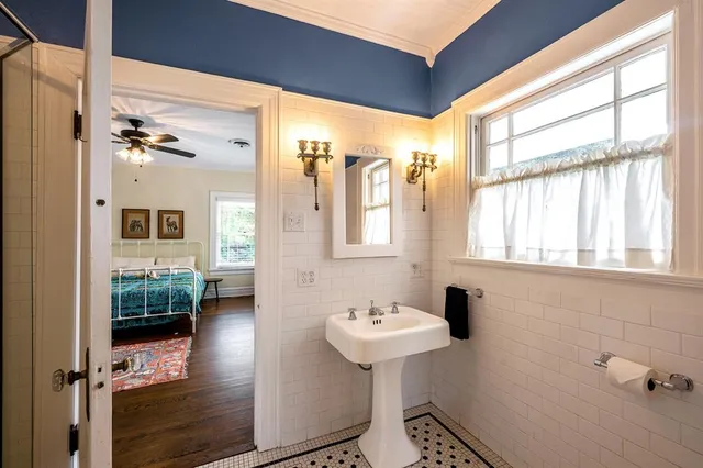a bathroom with a sink a mirror and next to a window