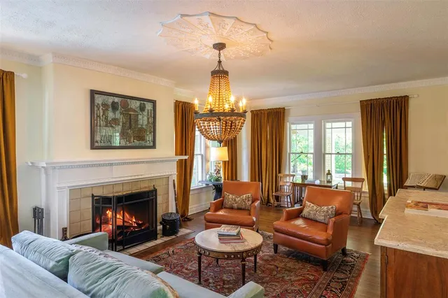 a living room with furniture a chandelier and a fireplace