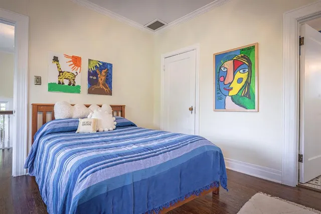 a bedroom with a bed and painting on the wall
