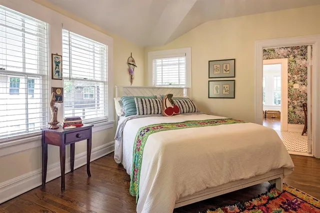 a view of a hallway with wooden floor and cabinet
