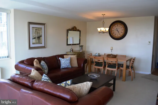 a living room with furniture a rug and wall clock