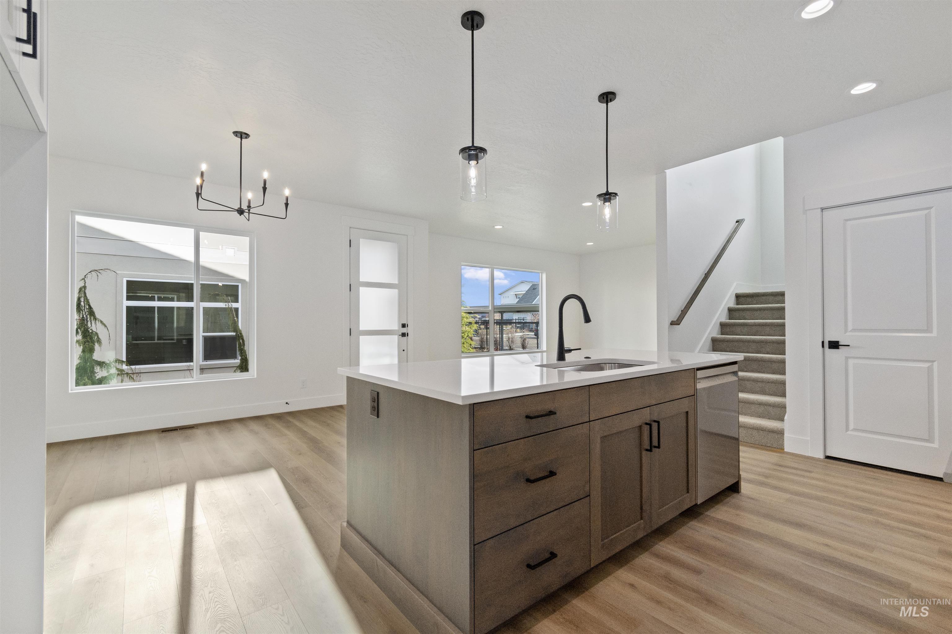 764 South Calhoun Lane Star, ID 83669 - Photo 15 of 48 Kitchen featuring hanging light fixtures, light wood-type flooring, an island with sink, a chandelier, and recessed lighting