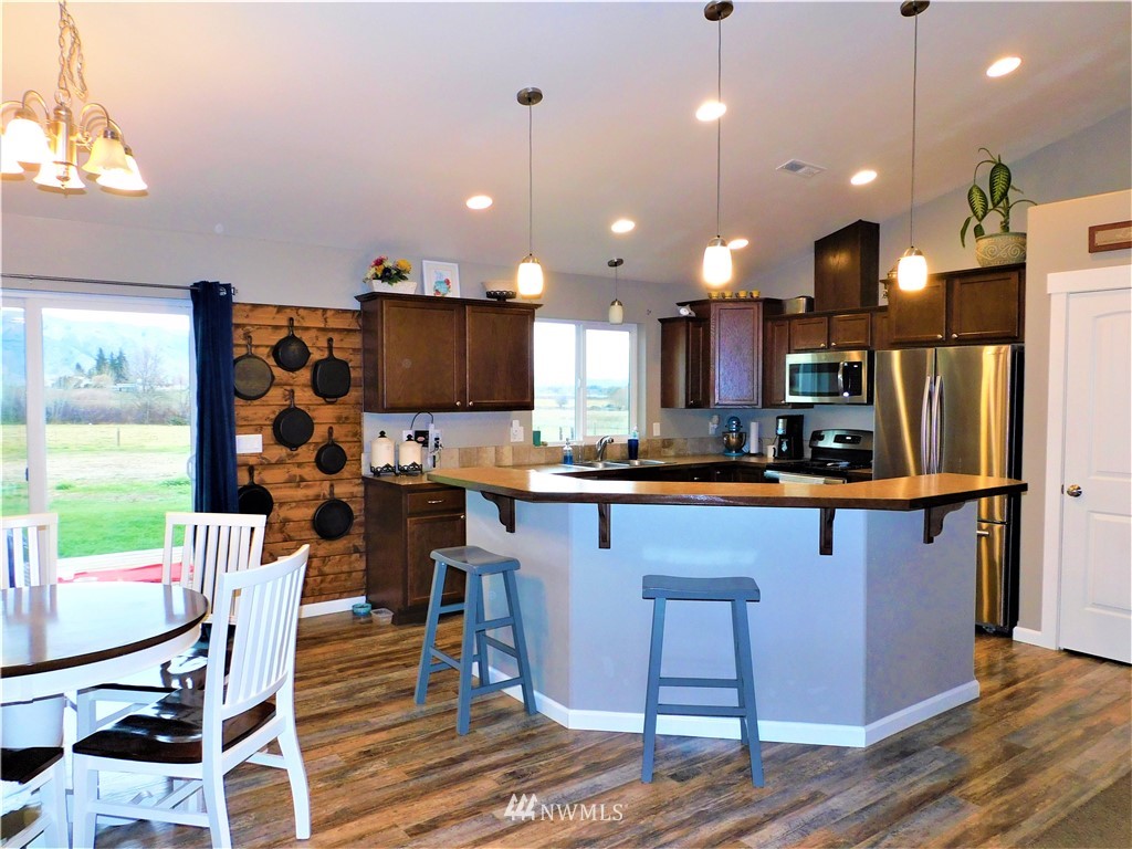 231 Sharp Road Tieton, WA 98947 - Photo 5 of 27 a kitchen with stainless steel appliances kitchen island granite countertop a table chairs and a refrigerator