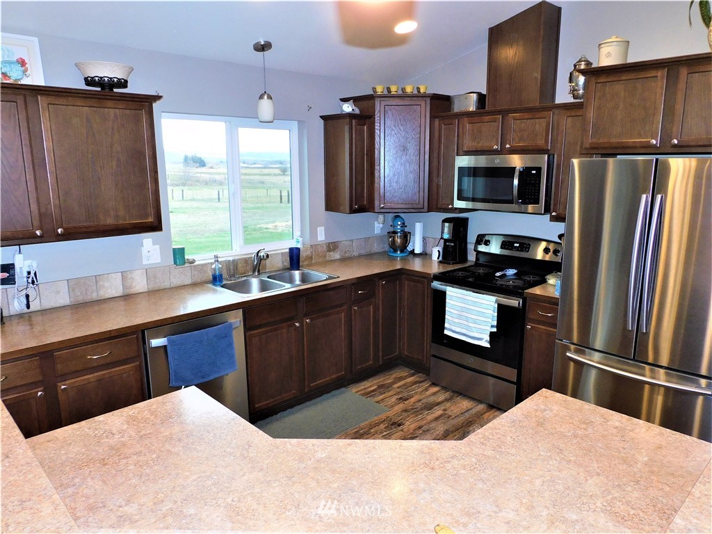 231 Sharp Road Tieton, WA 98947 - Photo 6 of 27 a kitchen with stainless steel appliances kitchen island granite countertop a refrigerator stove top oven and sink