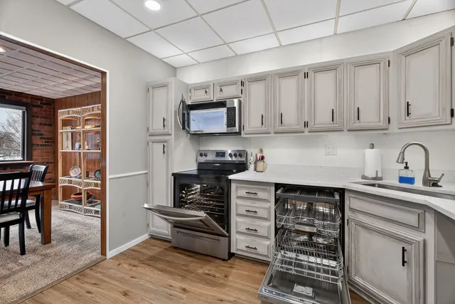 a kitchen with granite countertop a stove a sink and wooden cabinets