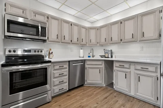 a kitchen with stainless steel appliances granite countertop a stove microwave and cabinets