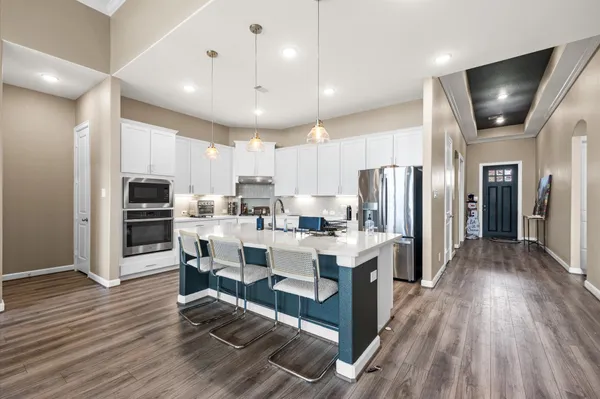 a kitchen with cabinets and wooden floor