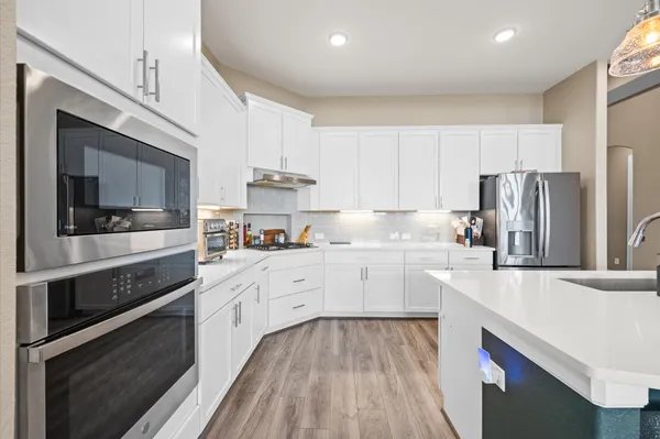 a kitchen with white cabinets and stainless steel appliances