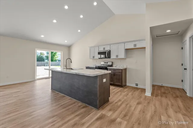 a kitchen with wooden floors and wooden cabinets