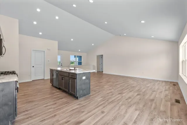 a large kitchen with wooden floor and a granite counter top