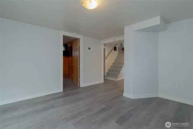 a view of hallway with stairs and wooden floor