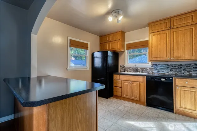 a kitchen with stainless steel appliances granite countertop a sink a refrigerator and a stove