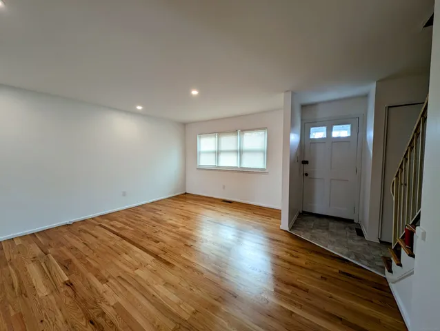 an empty room with wooden floor and a window