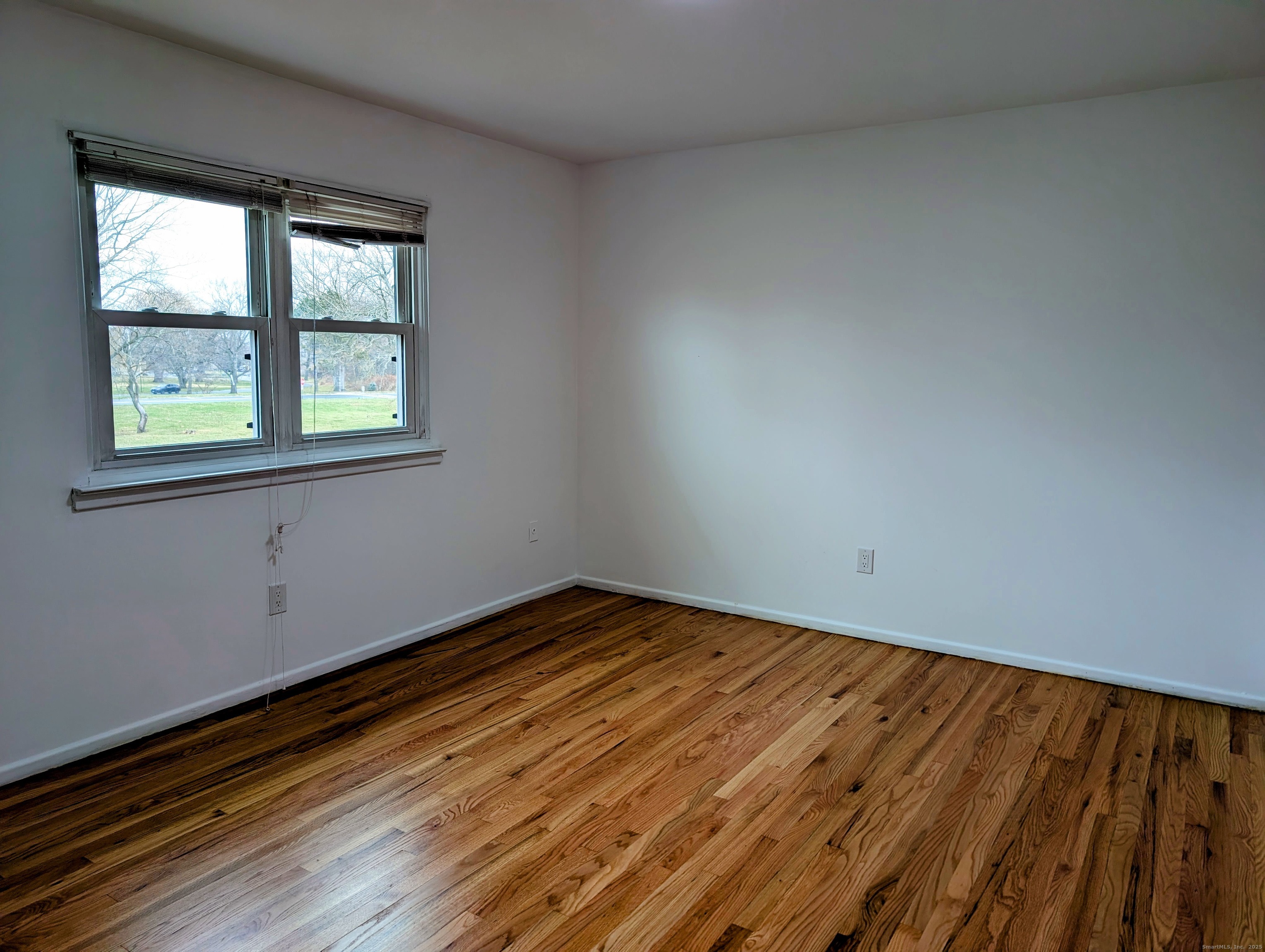 23 Shea Avenue, Unit 23 Milford, CT 06460 - Photo 12 of 16 an empty room with wooden floor and windows