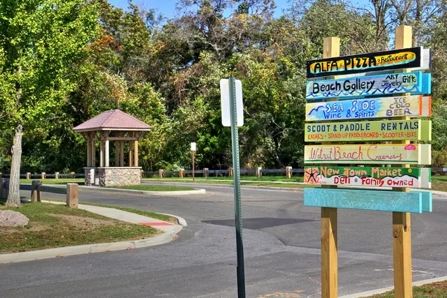 a front view of a multi story residential apartment building with yard and sign board