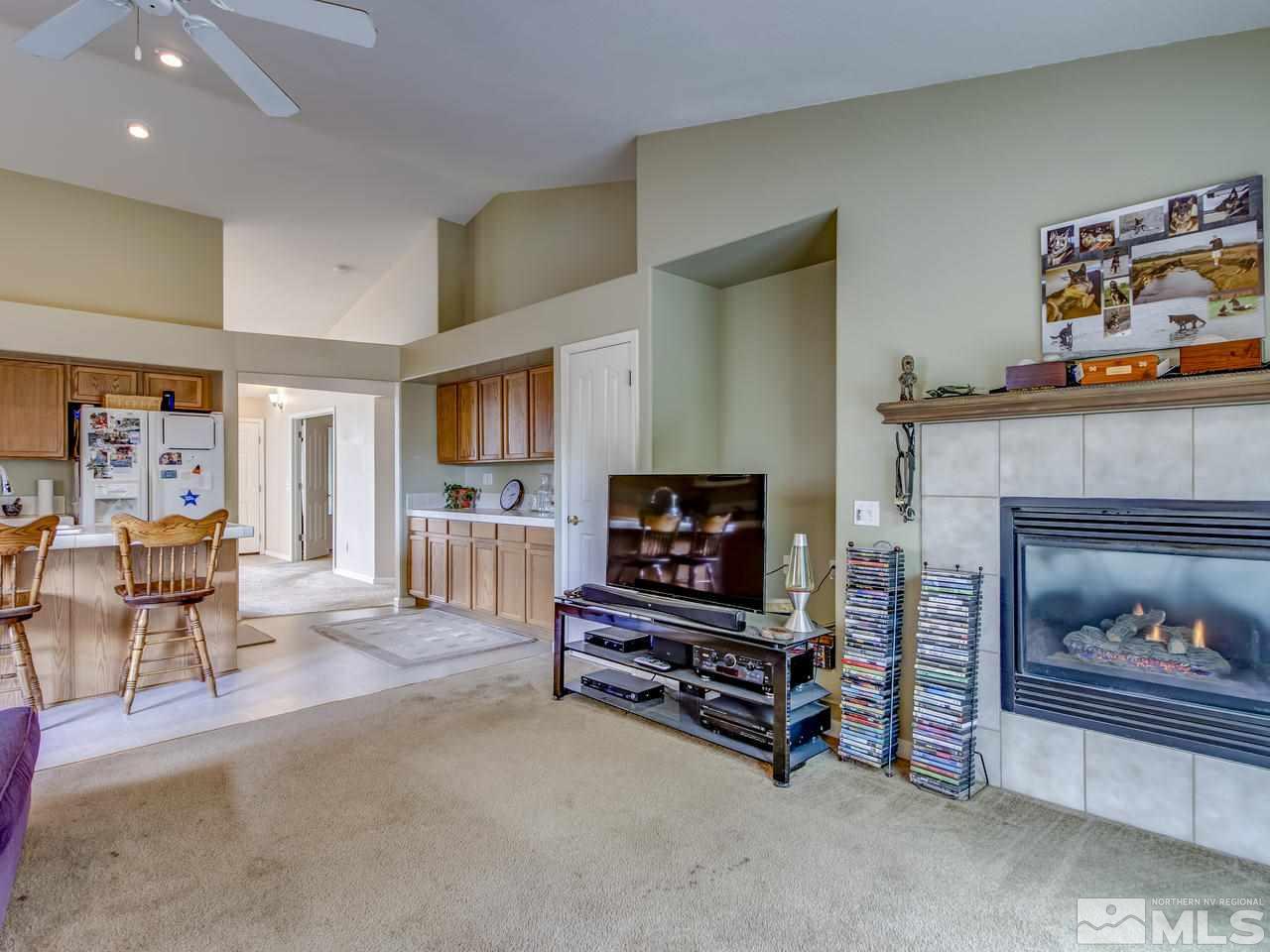 9665 Oakley Lane Reno, NV 89521 - Photo 12 of 23 a living room with furniture a flat screen tv and a fireplace