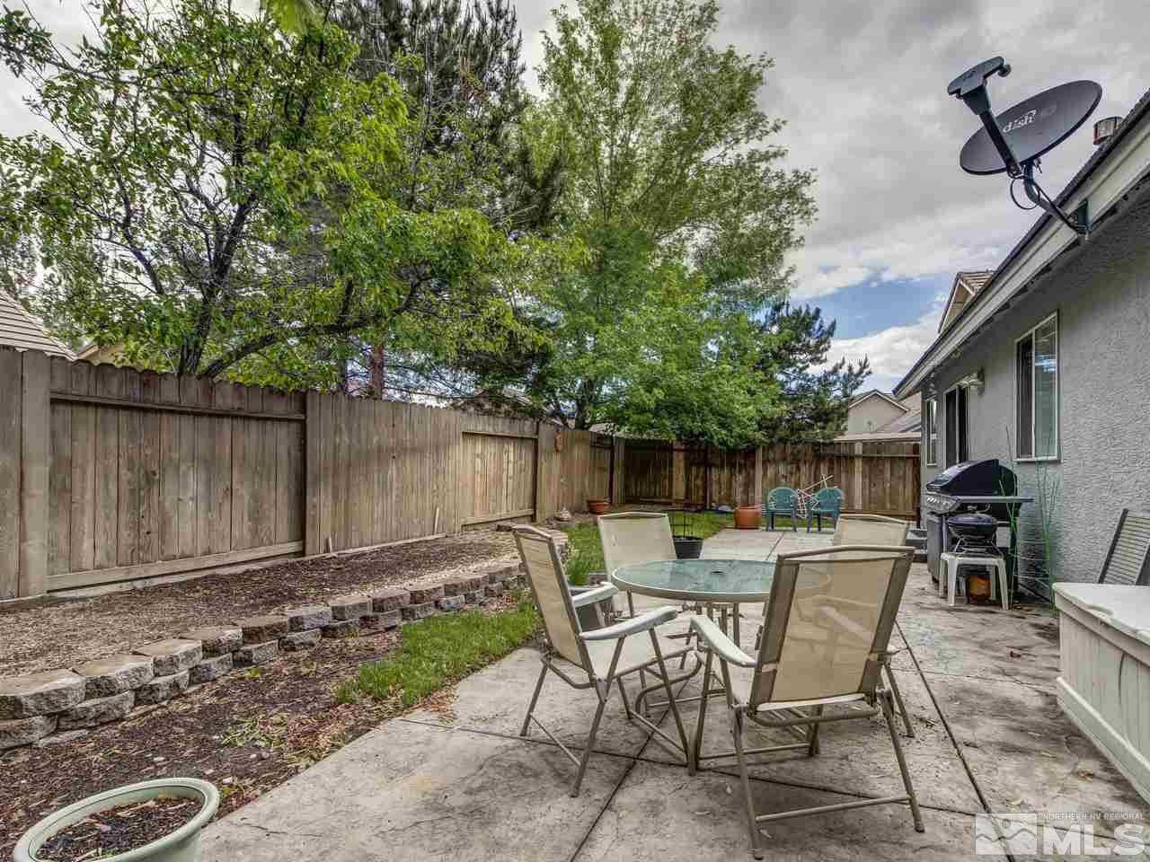 9665 Oakley Lane Reno, NV 89521 - Photo 23 of 23 a view of a backyard with table and chairs with wooden fence and plants