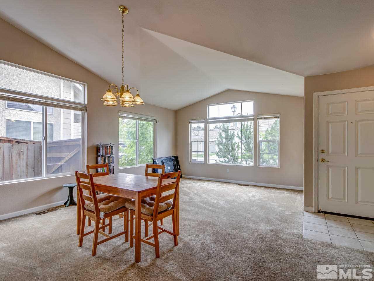 9665 Oakley Lane Reno, NV 89521 - Photo 3 of 23 a dining room with furniture a chandelier and a rug