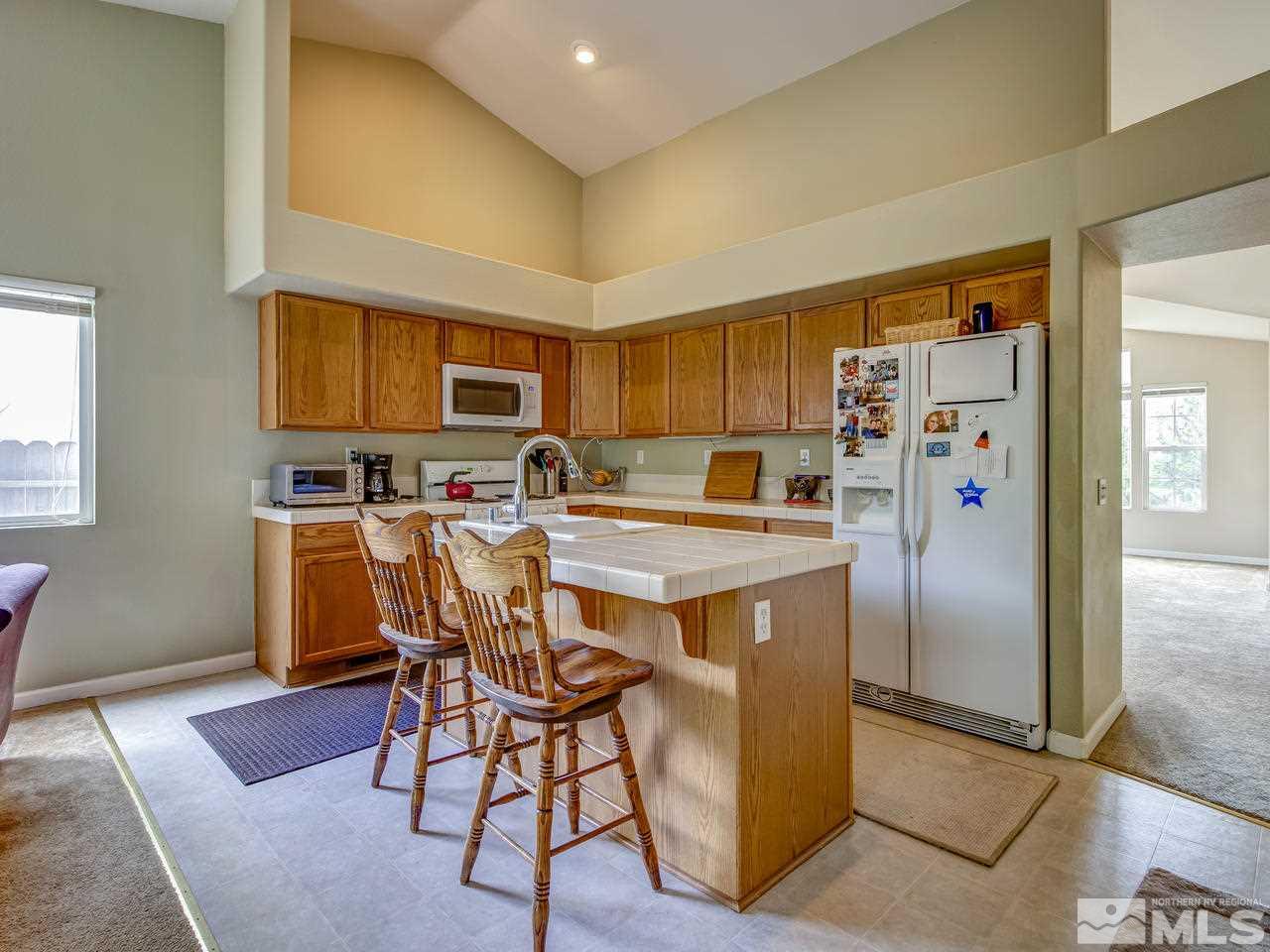 9665 Oakley Lane Reno, NV 89521 - Photo 8 of 23 a kitchen with stainless steel appliances granite countertop a refrigerator stove top oven a sink and dishwasher