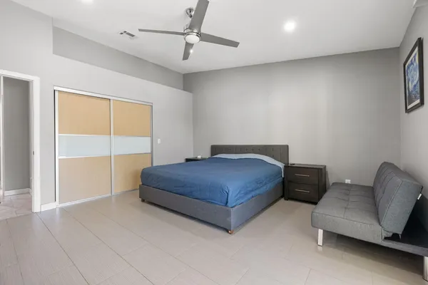 a bedroom with a bed and a potted plant