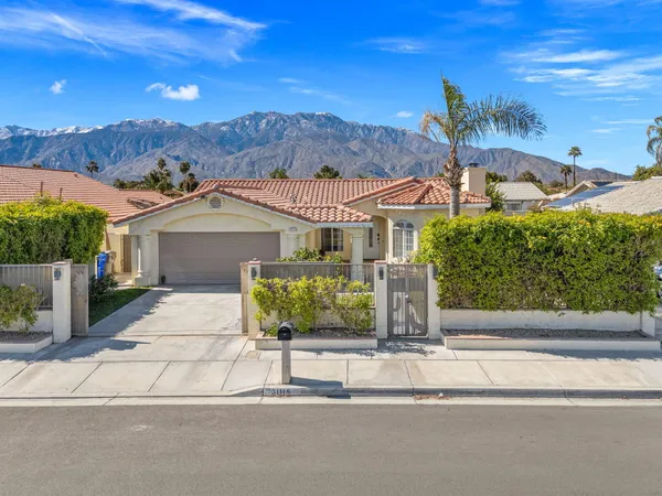 a kitchen with stainless steel appliances kitchen island granite countertop a dining table chairs and a refrigerator