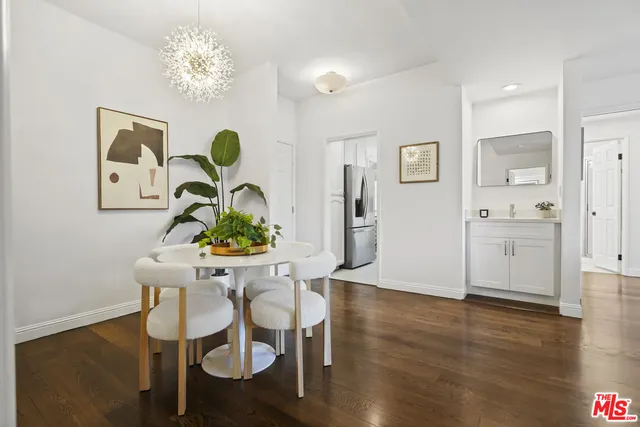 a dining room with furniture potted plants and wooden floor