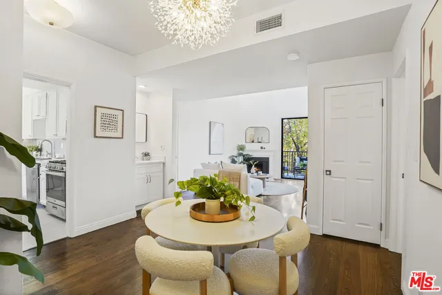 a dining room with furniture potted plants and wooden floor