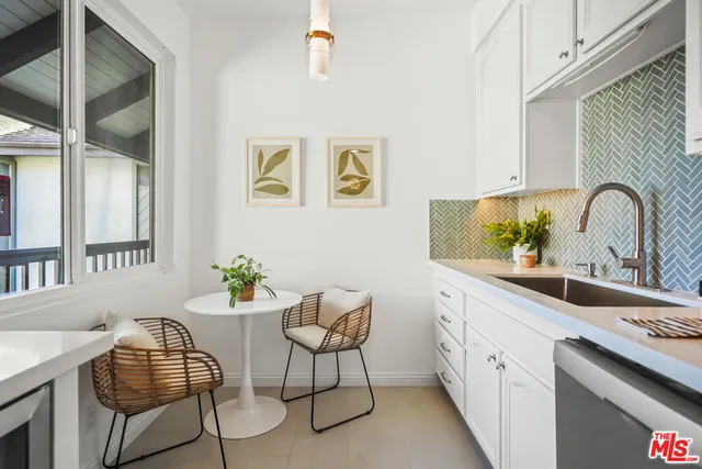 a kitchen with granite countertop white cabinets and stainless steel appliances