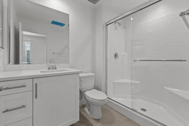 a bathroom with a shower sink vanity mirror and toilet
