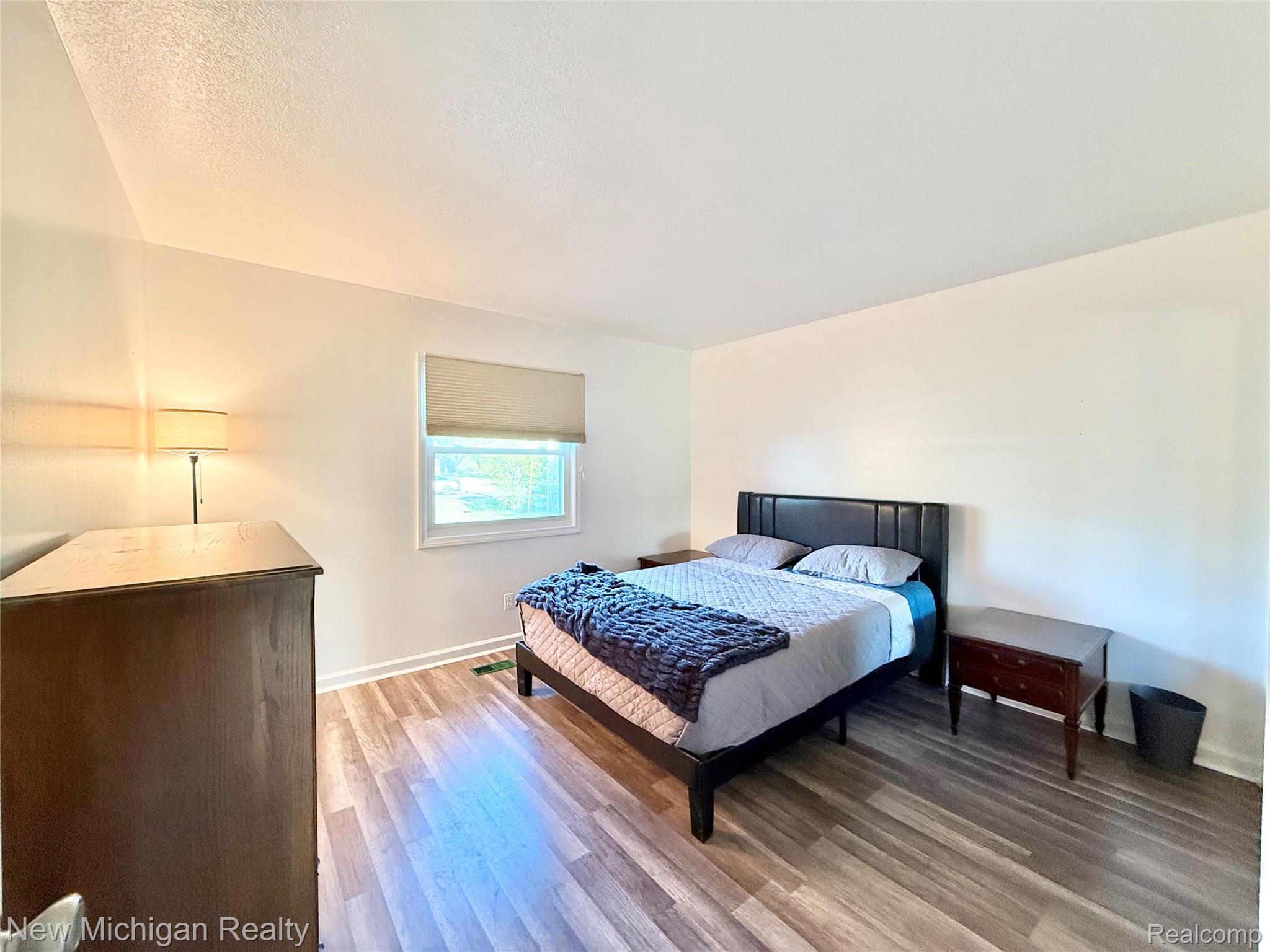 5288 Torrey Road Flint, MI 48507 - Photo 13 of 41 Bedroom featuring light wood-style flooring and a textured ceiling