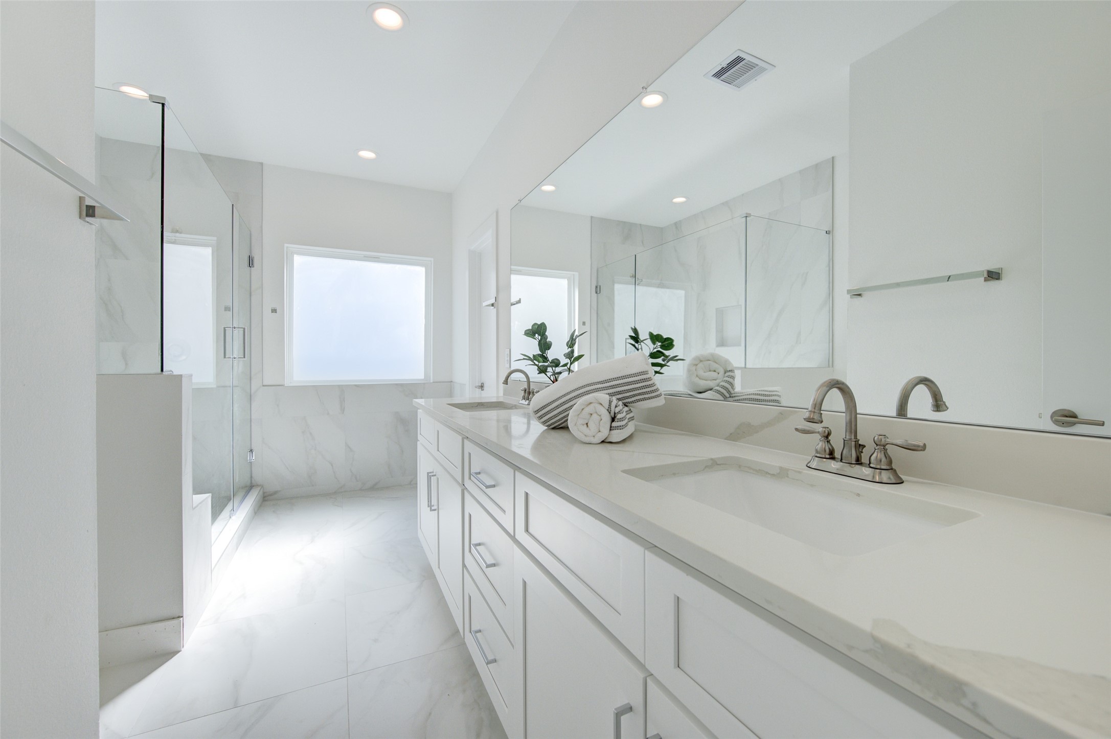 853 Mansfield Street, Unit A Houston, TX 77091 - Photo 12 of 16 Indulge in the opulence of a spacious, light-filled bathroom featuring a dual vanity, elegant countertops, and a large walk-in shower. The modern design and high-end fixtures create a spa-like retreat.