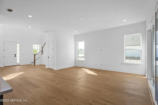 an empty room with wooden floor and window