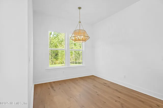 an empty room with windows & cabinet