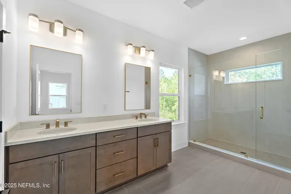 a bathroom with double sink and a mirror