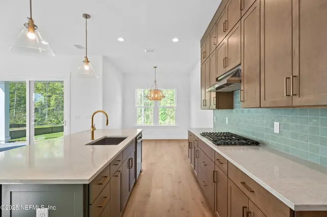 a kitchen with kitchen island stainless steel appliances a sink stove and cabinets