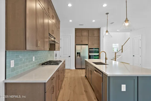 a kitchen with stainless steel appliances granite countertop a sink stove and refrigerator