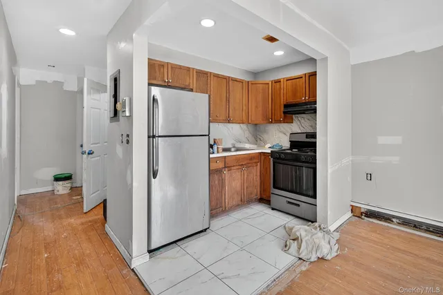 a kitchen with granite countertop a refrigerator stove and cabinets
