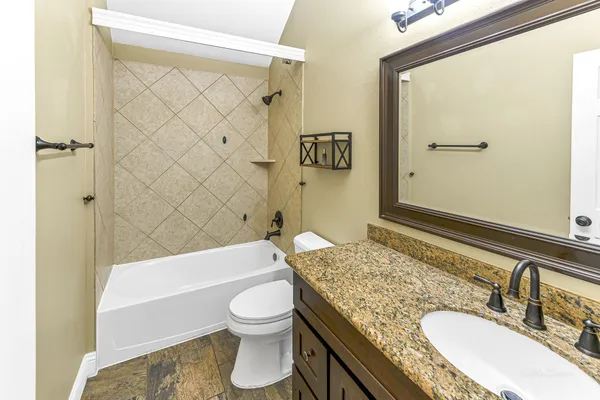 a bathroom with a granite countertop sink toilet and shower