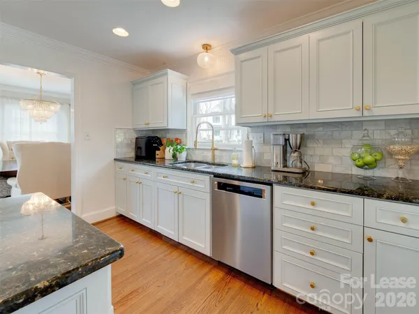 a kitchen with granite countertop a sink a stove and cabinets