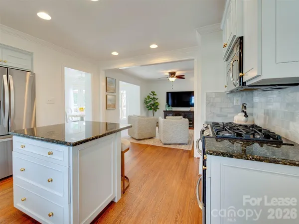 a kitchen with granite countertop a sink stove and cabinets