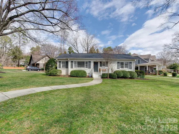 a view of a house with a big yard and large trees