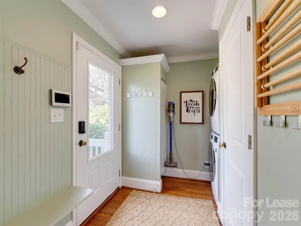 a view of a hallway with wooden floor and a bathroom