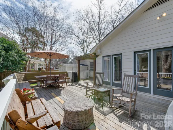 a patio with patio table and chairs under an umbrella with wooden floor