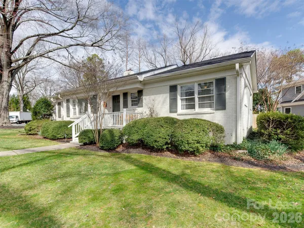a front view of a house with a yard and potted plants