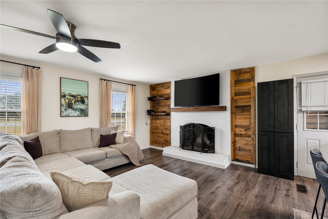 4508 Old Williamston Road Belton, SC 29627 - Photo 7 of 47 The living room features a fireplace, ceiling fan, and luxury vinyl plank flooring.