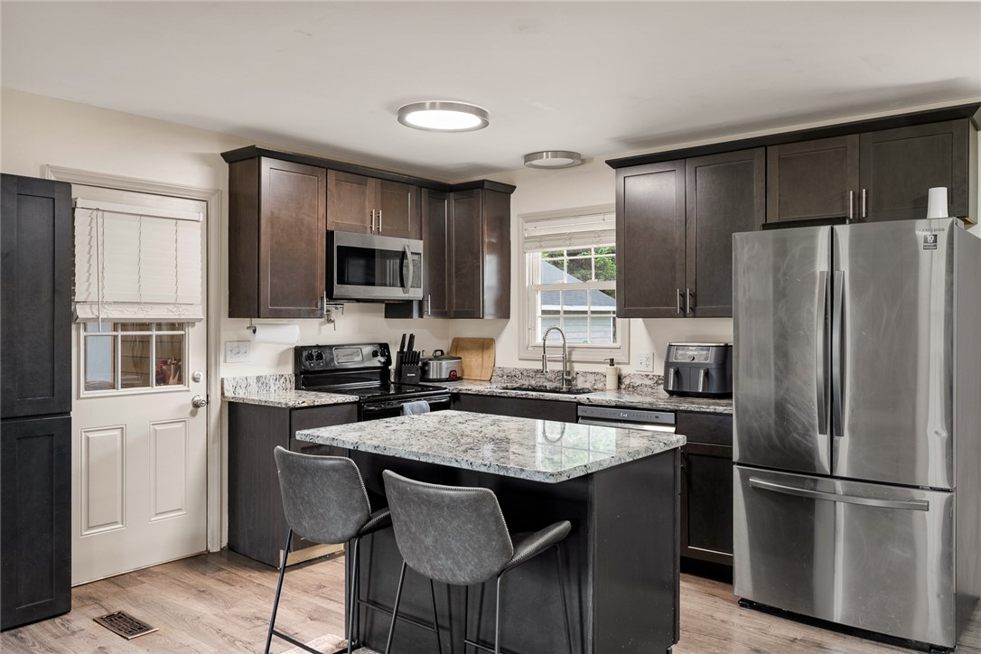 4508 Old Williamston Road Belton, SC 29627 - Photo 10 of 47 This updated kitchen features an island with seating, dark cabinetry, and stainless steel appliances.